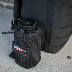 GORUCK black mesh water bottle holder attached to a rugged black rucksack, outdoor gear