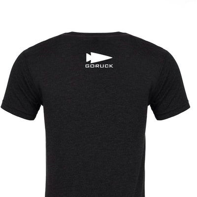 View of the back of a black America Tee - Tri-Blend from vendor-unknown, featuring a white GORUCK logo with an arrowhead design at the top center, printed in the USA.