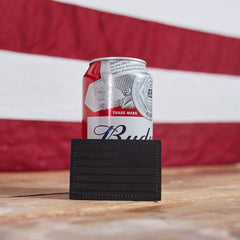 Black leather card holder by GORUCK on wood table, Budweiser can and US flag background