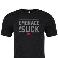 The Embrace the Suck Tee - Tri-Blend by vendor-unknown is a black T-shirt with a USMC-inspired phrase in bold gray letters across the chest and a small red arrow pointing to the right underneath.