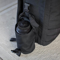 Black tactical backpack with a full panel water bottle pocket holding a black water bottle