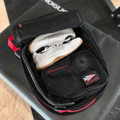 Open GORUCK gym bag with white sneakers and black mesh packing cube inside on gym floor