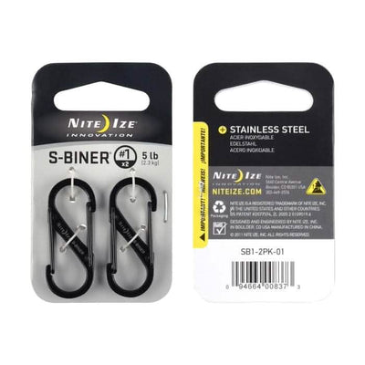 Packaging for the Nite Ize Carabiner - Hydration Bladder Attachment, ideal for securing to your rucksack. The front displays two black carabiners designed to support up to 5 lbs each. The back includes product information, usage warnings, and a barcode. These carabiners are crafted from durable stainless steel.