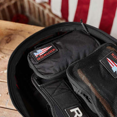 GORUCK Shadow Pocket M and mesh organizer inside black rucksack on wooden surface with American flag background