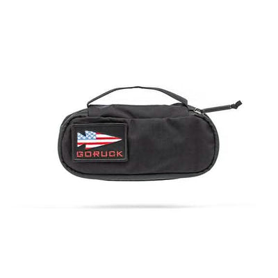 The GORUCK Shadow Pockets in black are designed from durable Cordura and include a convenient carrying handle. They feature a patch on the front with an American flag design next to the word GORUCK, making them perfect for efficient ruck organization.