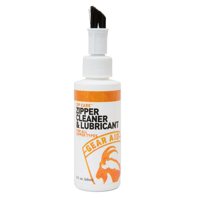 Gear Aid's Zip Care - Zipper Cleaner & Lubricant features a brush applicator on top, making it perfect for GORUCK Events. The white and orange label states that it's suitable for all zipper types and can be applied to create a protective film. The product has a capacity of 2 fl. oz. (60 ml).