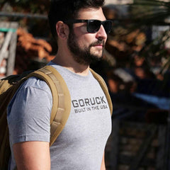 Man wearing GORUCK Built in the USA t-shirt and backpack outdoors in sunlight