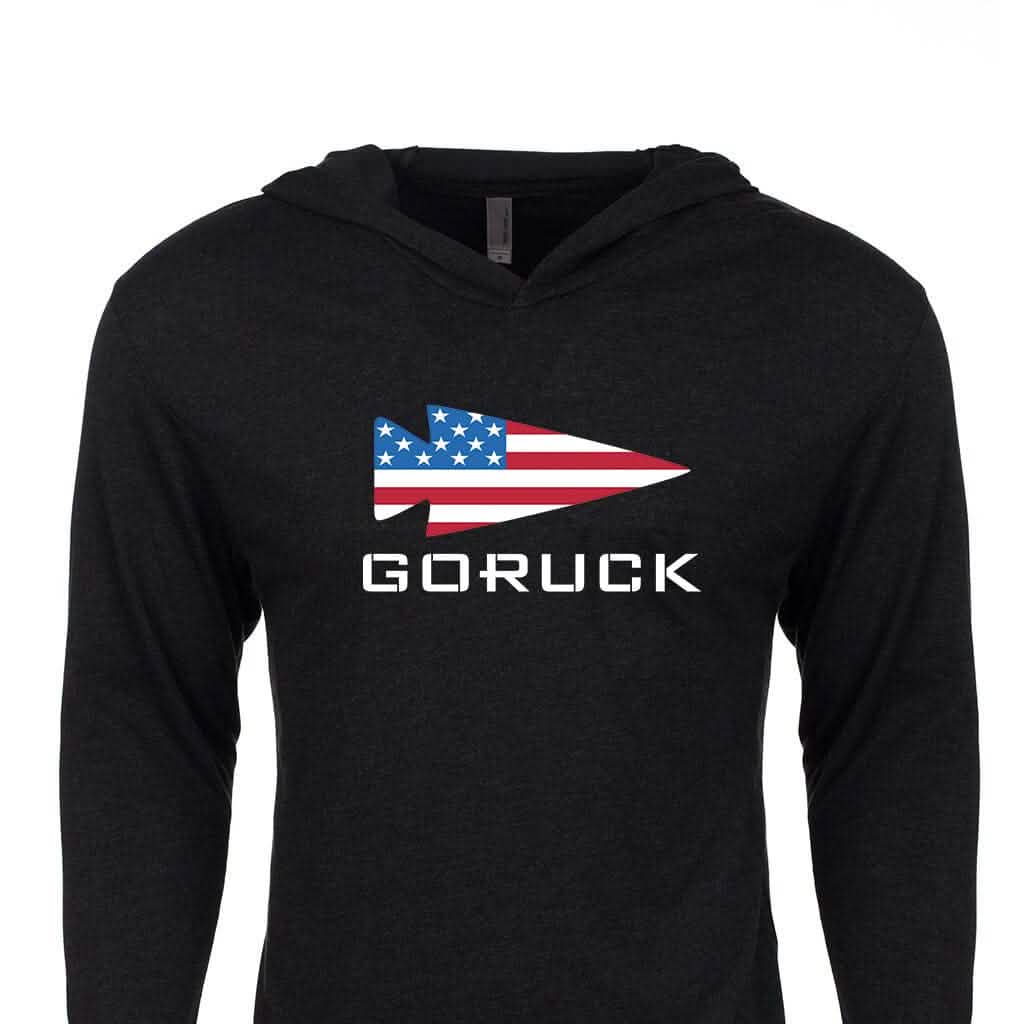 The GORUCK USA Hoodie - Tri-Blend by GORUCK is a black hoodie that features the iconic GORUCK logo, with a stylized spearhead adorned with an American flag design and the word 
