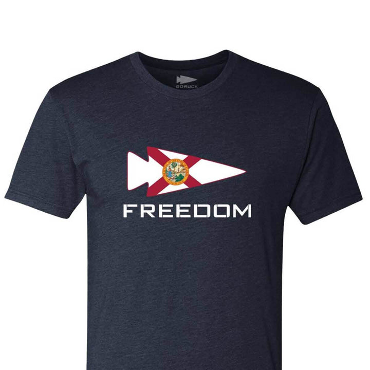 A dark gray Freedom Tee - Tri-Blend from vendor-unknown features the word FREEDOM beneath a shark graphic embellished with the Sunshine State flag design, perfect for fans of Florida GRTs.