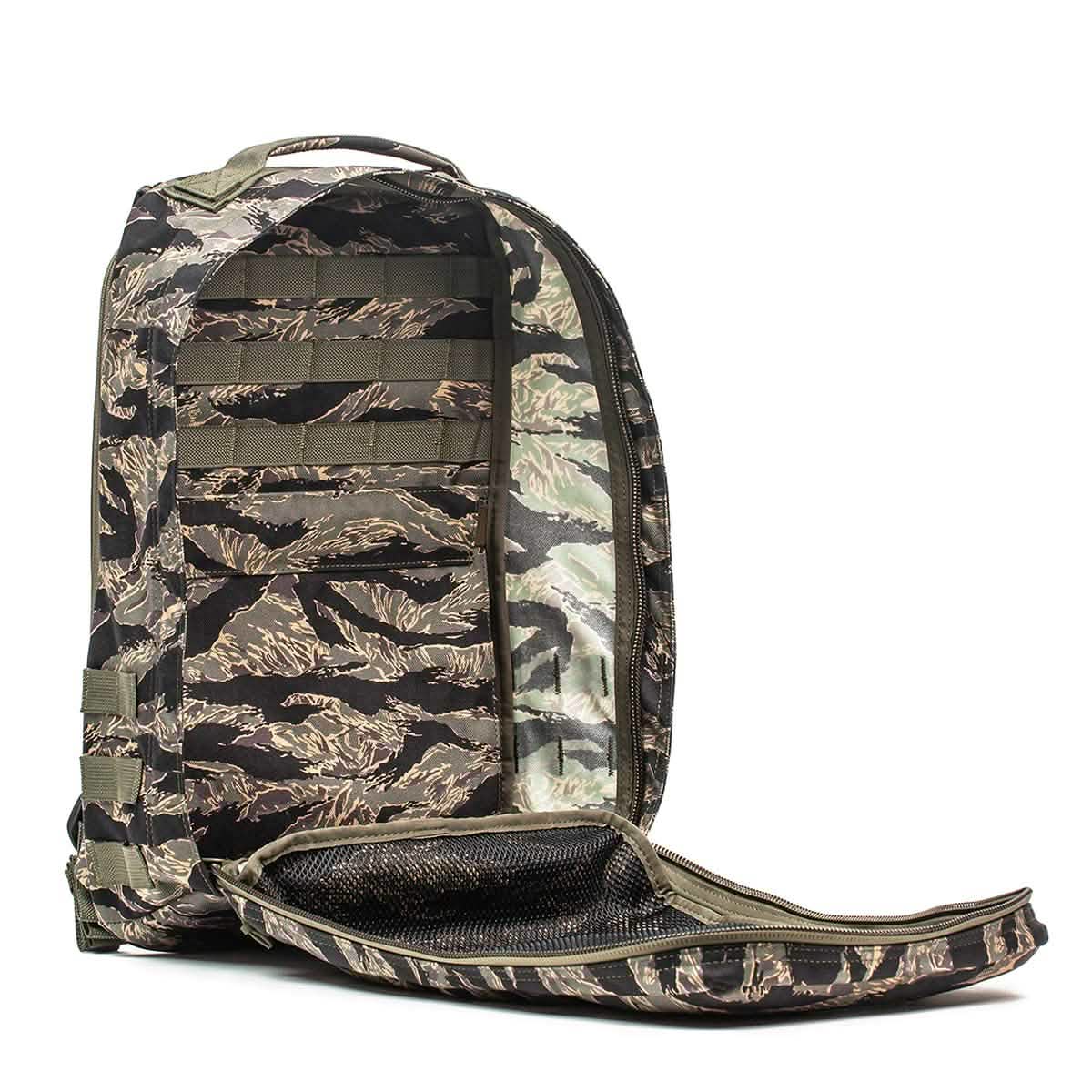 The GR1 - USA - Tiger Stripe backpack, featuring a camouflage pattern, is displayed with its main compartment unzipped and open against a white background.