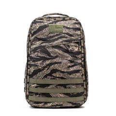 The GR1 - USA - Tiger Stripe is a camouflage-patterned rucksack with multiple compartments, olive green horizontal straps, and rugged American-made quality.