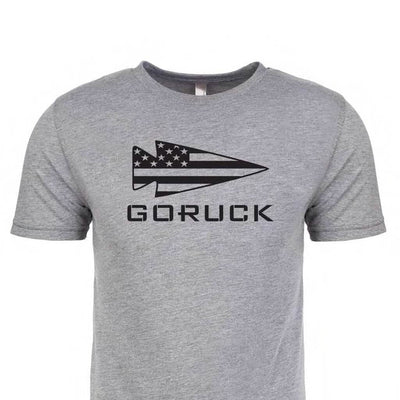 The GORUCK USA Tee - Tri-blend from vendor-unknown is a premium gray T-shirt that showcases "GORUCK" alongside a stylized arrow logo with the American flag, capturing the essence of the GORUCK spearhead.