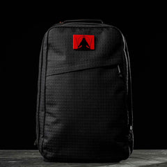 A black GR1 USA x Carryology - GRXC2 Samurai backpack made from Japanese cotton, featuring a red patch with a black abstract design. Part of the exclusive Samurai GR1 collection.