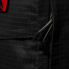 Close-up of black zippers on a textured Japanese cotton fabric bag with a red patch, part of the GR1 USA x Carryology - GRXC2 Samurai collaboration.