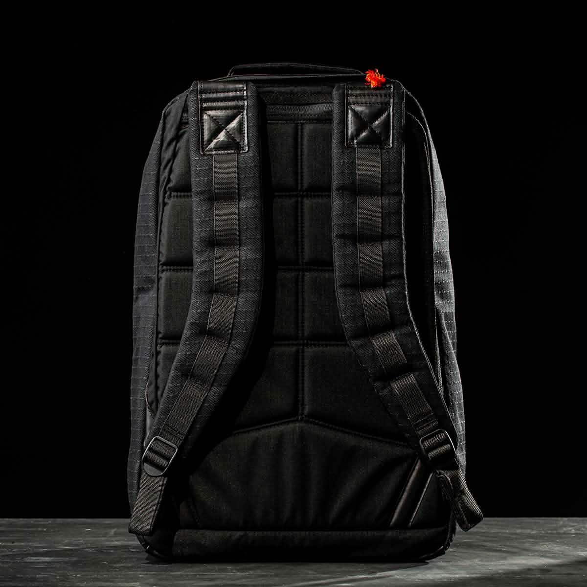 The GR1 USA x Carryology - GRXC2 Samurai backpack stands upright, shown from the back with padded straps and a small red detail—crafted in collaboration using premium Japanese cotton fabric.