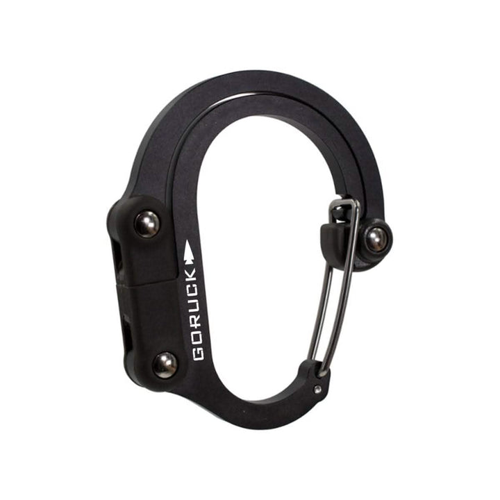 Sleek black Heroclip with the GORUCK logo, featuring a wire gate and two visible locking screws. The brand name "Heroclip" is printed in white along one side of this versatile gear clip, making it perfect for any adventure.