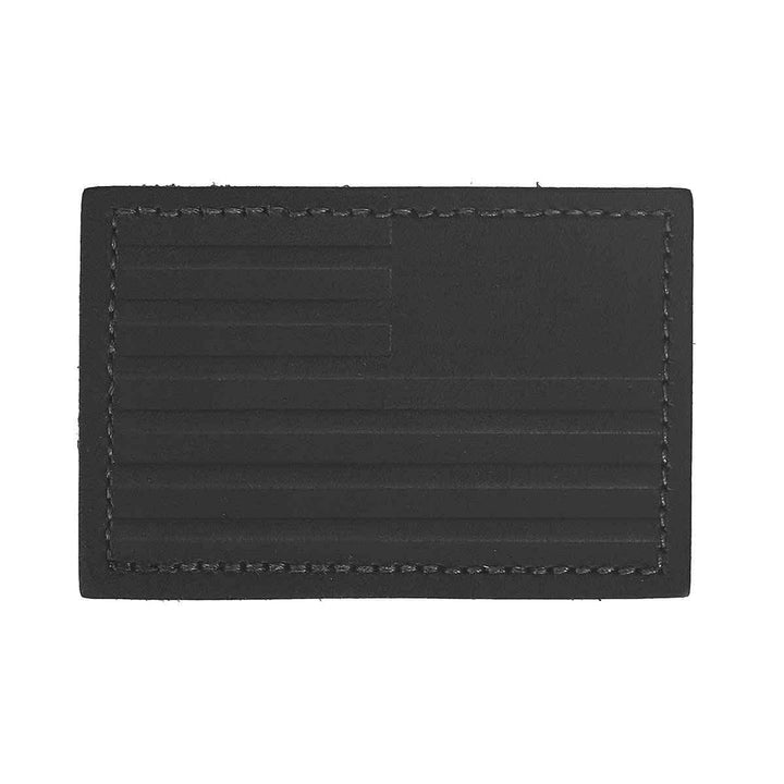 Introducing the "Patch - Leather Reverse Flag" by vendor-unknown: a genuine leather patch featuring an embossed American flag design with stars and stripes, complemented by a stitched border and durable VELCRO® backing.