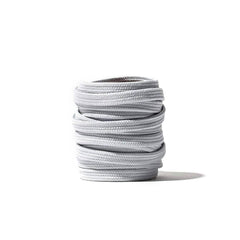 A spool of GORUCK Flat Laces in gray is coiled neatly against a plain white background.