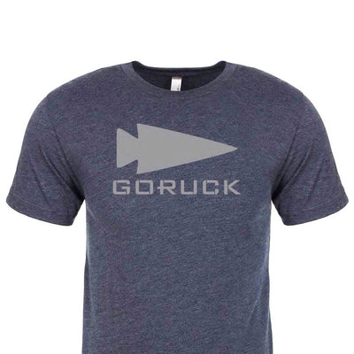 Introducing the "Three Rules Tee - Tri-Blend" : A dark blue t-shirt made from premium tri-blend fabric, adorned with a bold gray triangle and the word GORUCK across the front. Renowned for its superior quality and style, this shirt is crafted with pride in the USA against a pristine white backdrop.